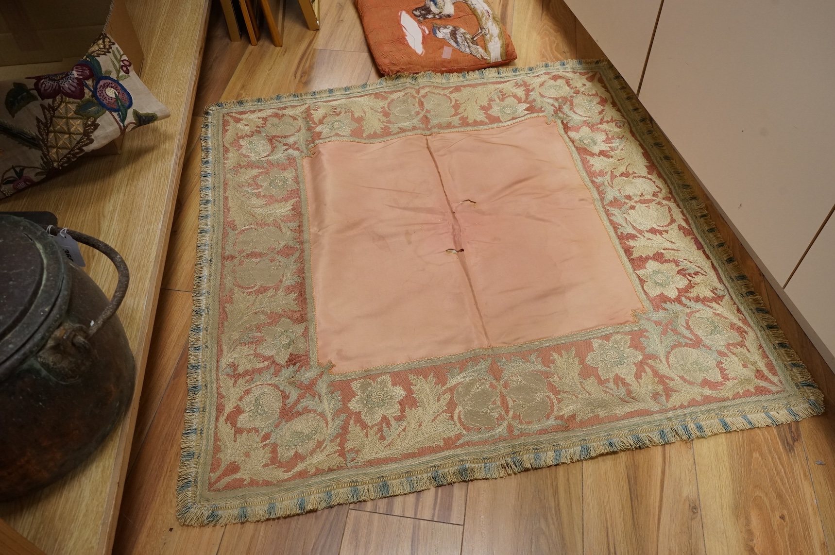 An Arts and Crafts embroidered table cover, an embroidered printed fabric sample later embroidered and a bird embroidered cushion.